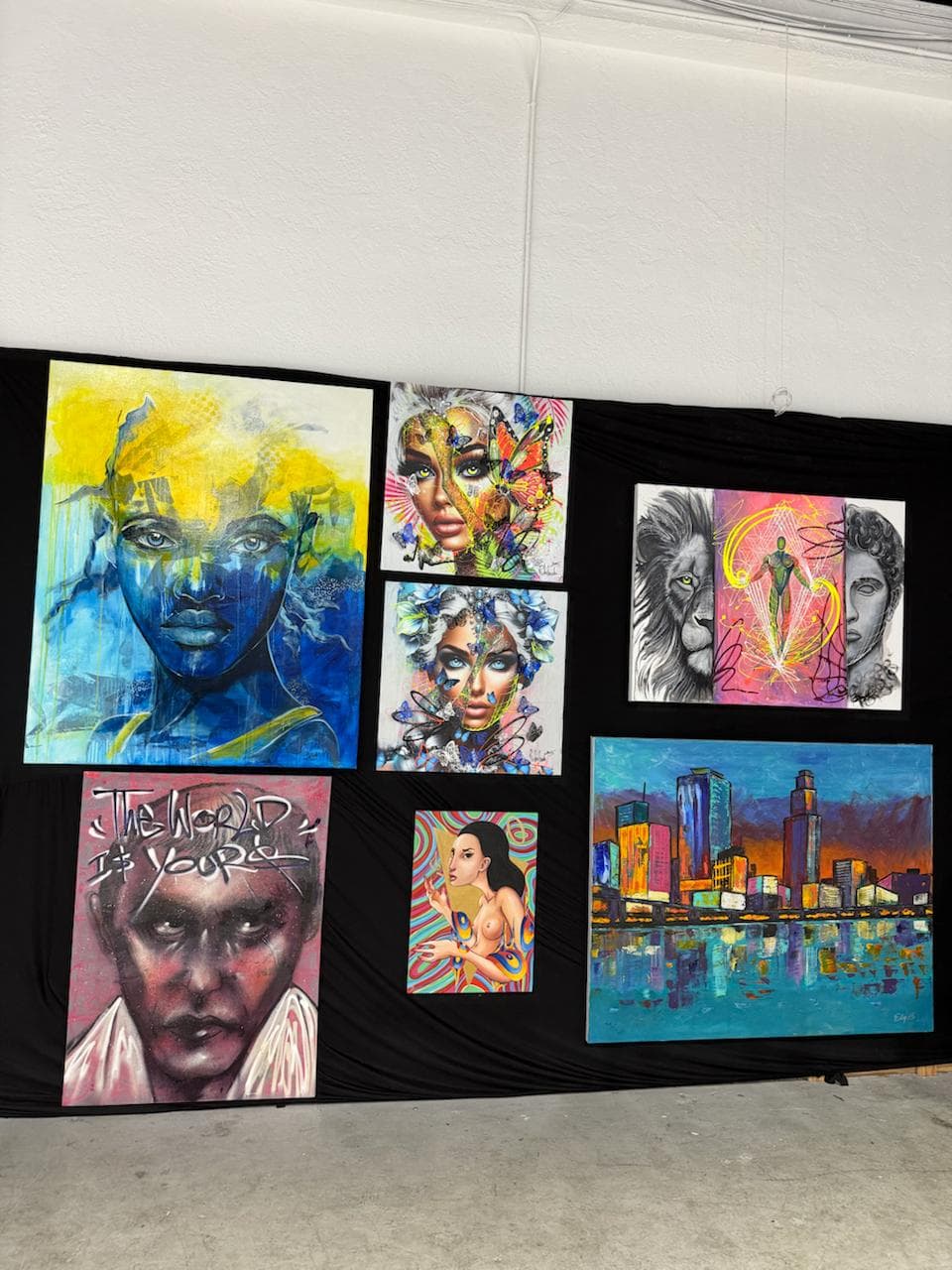 Jason Perez Art pieces installed on a black gallery wall inside Revos Auto Group